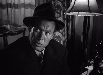 Movie still from “The Maltese Falcon” (1941), directed by John Huston – A man wearing a hat and a suit and tie; Close Up shot, Low angle
