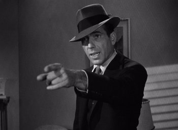 Movie still from “The Maltese Falcon” (1941), directed by John Huston – A black and white photo of a man in a suit and a hat; Close Up shot, Low angle