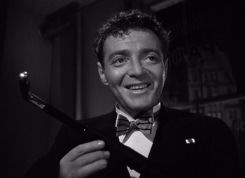 Movie still from “The Maltese Falcon” (1941), directed by John Huston – A black and white photo of a man holding a tie; Close Up shot, Low angle