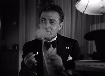 Movie still from “The Maltese Falcon” (1941), directed by John Huston – A black and white photo of a man smoking a cigarette; Close Up shot, Low angle