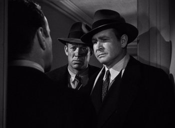 Movie still from “The Maltese Falcon” (1941), directed by John Huston – Two men in suits and hats looking at each other in a mirror; Medium shot, Low angle