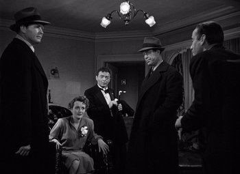 Movie still from “The Maltese Falcon” (1941), directed by John Huston – A black and white photo of a group of men and a woman; Medium shot, High angle