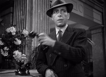 Movie still from “The Maltese Falcon” (1941), directed by John Huston – A man in a suit and hat holding a gavel; Close Up shot, Low angle