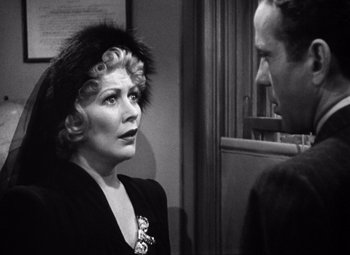 Movie still from “The Maltese Falcon” (1941), directed by John Huston – An old photo of a man and a woman talking to each other; Close Up shot, Over the shoulder angle