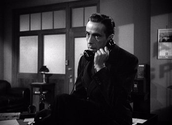 Movie still from “The Maltese Falcon” (1941), directed by John Huston – A black and white photo of a man talking on a phone; Close Up shot, Low angle