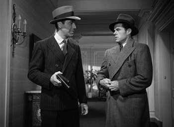 Movie still from “The Maltese Falcon” (1941), directed by John Huston – Two men in suits and hats talking to each other; Medium shot, High angle