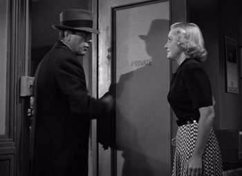 Movie still from “The Maltese Falcon” (1941), directed by John Huston – A man and a woman shaking hands in a black and white photo; Medium shot, Low angle