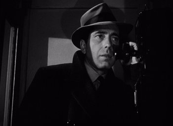 Movie still from “The Maltese Falcon” (1941), directed by John Huston – A black and white photo of a man in a suit and a hat; Close Up shot, Low angle