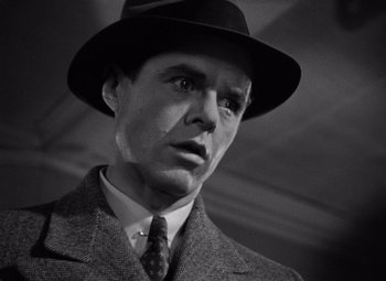 Movie still from “The Maltese Falcon” (1941), directed by John Huston – A man wearing a suit and a hat; Close Up shot, Low angle