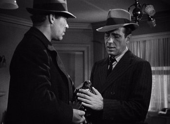 Movie still from “The Maltese Falcon” (1941), directed by John Huston – Two men in suits and hats talking to each other; Close Up shot, Over the shoulder angle