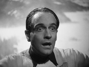Movie still from “The Man Who Knew Too Much” (1934), directed by Alfred Hitchcock – An old black and white photo of a man with a surprised look on his face; Close Up shot, Low angle
