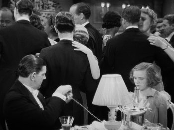 Movie still from “The Man Who Knew Too Much” (1934), directed by Alfred Hitchcock – A black and white photo of people at a formal event; Medium shot, High angle