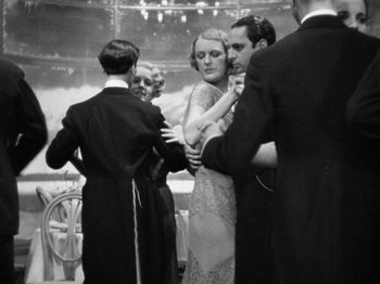 Movie still from “The Man Who Knew Too Much” (1934), directed by Alfred Hitchcock – A black and white photo of a group of people; Medium shot, Low angle