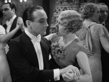 Movie still from “The Man Who Knew Too Much” (1934), directed by Alfred Hitchcock – A man and a woman dancing at an event; Medium shot, Low angle