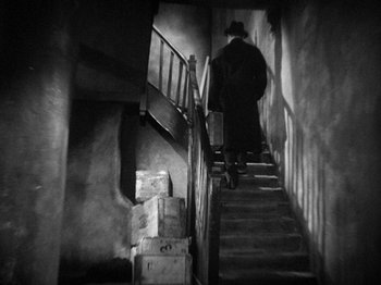 Movie still from “The Man Who Knew Too Much” (1934), directed by Alfred Hitchcock – A man walking down a set of stairs; Wide shot, Low angle