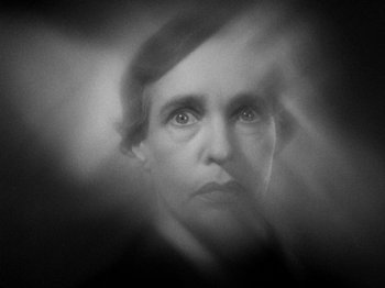 Movie still from “The Man Who Knew Too Much” (1934), directed by Alfred Hitchcock – A black - and - white photo of a woman's face; Extreme Close Up shot, Low angle
