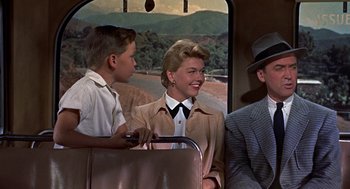 Movie still from “The Man Who Knew Too Much” (1956), directed by Alfred Hitchcock – A man and a woman riding on a bus with a young boy; Medium shot, Over the shoulder angle