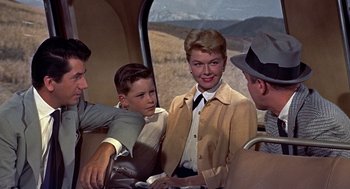Movie still from “The Man Who Knew Too Much” (1956), directed by Alfred Hitchcock – A group of people riding on a bus together; Medium shot, High angle