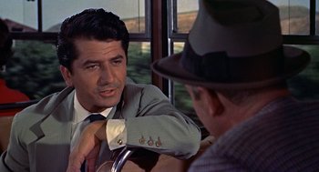 Movie still from “The Man Who Knew Too Much” (1956), directed by Alfred Hitchcock – A man in a suit and tie talking to another man in a hat; Close Up shot, Over the shoulder angle