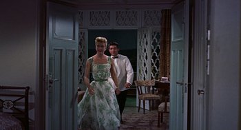 Movie still from “The Man Who Knew Too Much” (1956), directed by Alfred Hitchcock – A man and a woman are walking through a room; Wide shot, Low angle