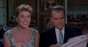 Movie still from “The Man Who Knew Too Much” (1956), directed by Alfred Hitchcock – An older man and a younger woman sitting next to each other; Medium shot, Low angle