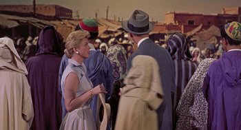 Movie still from “The Man Who Knew Too Much” (1956), directed by Alfred Hitchcock – A group of people standing in a room; Medium shot, Over the shoulder angle