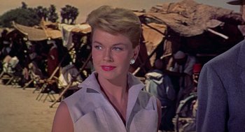 Movie still from “The Man Who Knew Too Much” (1956), directed by Alfred Hitchcock – A woman in a white shirt is looking at the camera; Close Up shot, Low angle