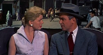 Movie still from “The Man Who Knew Too Much” (1956), directed by Alfred Hitchcock – A man and a woman sitting next to each other; Close Up shot, Over the shoulder angle