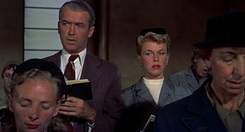 Movie still from “The Man Who Knew Too Much” (1956), directed by Alfred Hitchcock – A man and a woman standing next to each other; Medium shot, Low angle