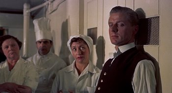 Movie still from “The Man Who Knew Too Much” (1956), directed by Alfred Hitchcock – A group of people standing next to each other in a room; Medium shot, Over the shoulder angle