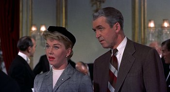 Movie still from “The Man Who Knew Too Much” (1956), directed by Alfred Hitchcock – A man and a woman standing next to each other; Close Up shot, Low angle