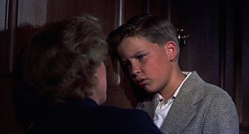 Movie still from “The Man Who Knew Too Much” (1956), directed by Alfred Hitchcock – A young boy and an older woman are talking to each other; Close Up shot, Over the shoulder angle