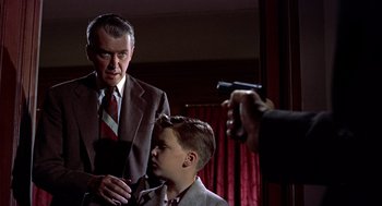 Movie still from “The Man Who Knew Too Much” (1956), directed by Alfred Hitchcock – An older man and a young boy in a suit and tie; Medium shot, Low angle