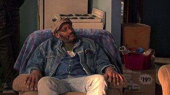 Movie still from “The Man from Earth” (2007), directed by Richard Schenkman – A man sitting on a chair in a living room; Medium shot, High angle