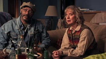 Movie still from “The Man from Earth” (2007), directed by Richard Schenkman – A man and a woman sitting on a couch with drinks; Medium shot, High angle