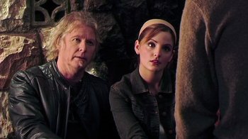 Movie still from “The Man from Earth” (2007), directed by Richard Schenkman – A man and a woman sitting next to each other in front of a stone wall; Close Up shot, Over the shoulder angle