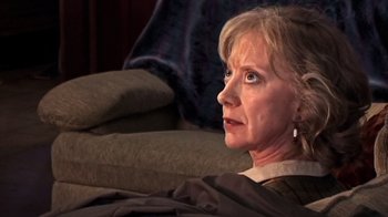 Movie still from “The Man from Earth” (2007), directed by Richard Schenkman – An older woman sitting on a couch looking off into the distance; Close Up shot, Over the shoulder angle