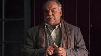 Movie still from “The Man from Earth” (2007), directed by Richard Schenkman – An older man wearing a jacket and a scarf; Close Up shot, Low angle