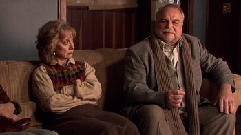 Movie still from “The Man from Earth” (2007), directed by Richard Schenkman – An older man and woman sitting next to each other on a couch; Medium shot, High angle