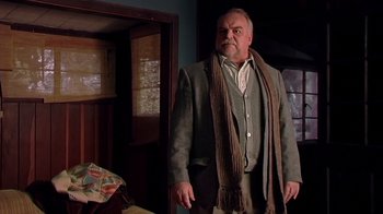 Movie still from “The Man from Earth” (2007), directed by Richard Schenkman – An older man wearing a jacket and a scarf; Medium shot, Low angle