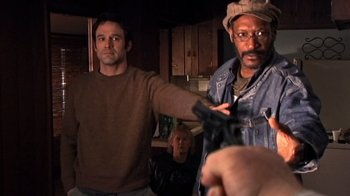 Movie still from “The Man from Earth” (2007), directed by Richard Schenkman – Two men in a kitchen holding a gun; Medium shot, Over the shoulder angle