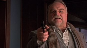 Movie still from “The Man from Earth” (2007), directed by Richard Schenkman – An older man holding a gun in his right hand; Close Up shot, Low angle