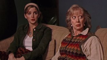 Movie still from “The Man from Earth” (2007), directed by Richard Schenkman – Two women sitting on a couch looking at the camera; Medium shot, Over the shoulder angle