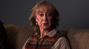 Movie still from “The Man from Earth” (2007), directed by Richard Schenkman – An older woman sitting on a couch in front of a window; Close Up shot, Low angle