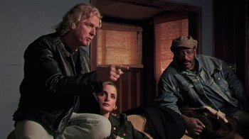 Movie still from “The Man from Earth” (2007), directed by Richard Schenkman – A man and a woman sitting next to a man in a hat; Medium shot, Over the shoulder angle