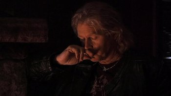 Movie still from “The Man from Earth” (2007), directed by Richard Schenkman – An older man smoking a cigarette in a dark room; Close Up shot, Low angle