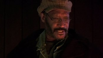 Movie still from “The Man from Earth” (2007), directed by Richard Schenkman – A person wearing glasses and a hat; Close Up shot, Low angle