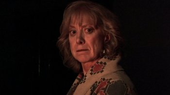 Movie still from “The Man from Earth” (2007), directed by Richard Schenkman – An older woman in a patterned shirt looking at the camera; Close Up shot, Low angle