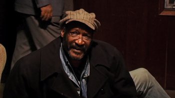 Movie still from “The Man from Earth” (2007), directed by Richard Schenkman – An older man wearing glasses and a hat; Close Up shot, High angle