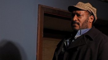 Movie still from “The Man from Earth” (2007), directed by Richard Schenkman – A man wearing a hat standing in front of a mirror; Close Up shot, Low angle